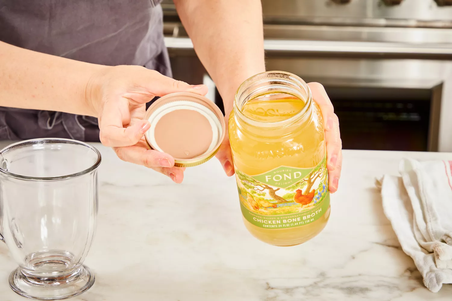 A person opens a jar of FOND Certified Organic Chicken Bone Broth