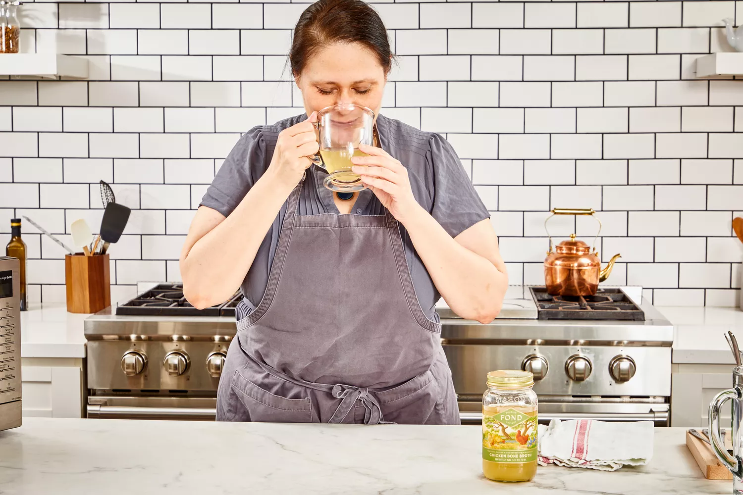 A person drinks a glass of FOND Certified Organic Chicken Bone Broth