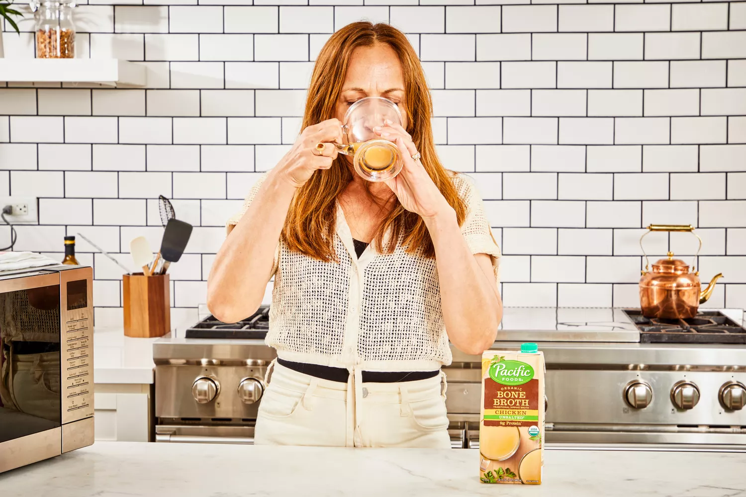 A person drinks a glass of Pacific Foods Chicken Bone Broth