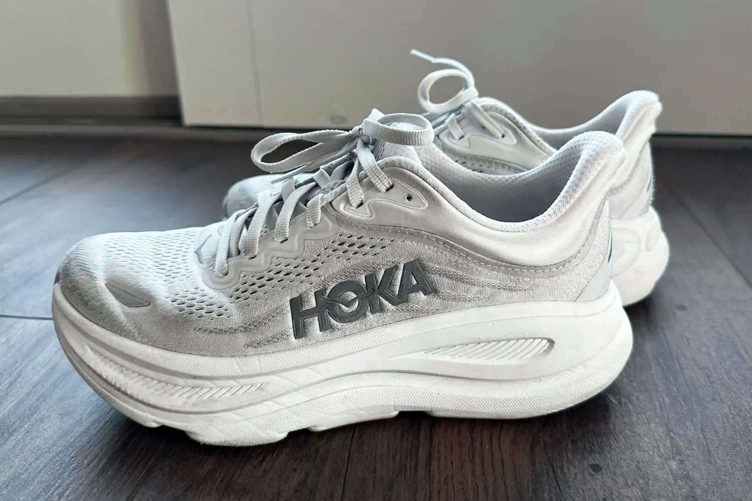 A pair of Hoka Bondi 9 shoes on a wooden floor