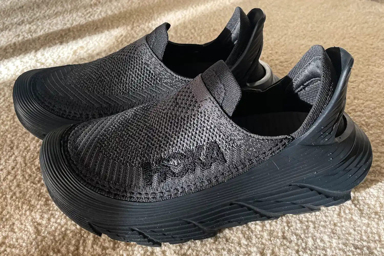 A side view of a pair of Hoka Restore TC Recovery Shoes