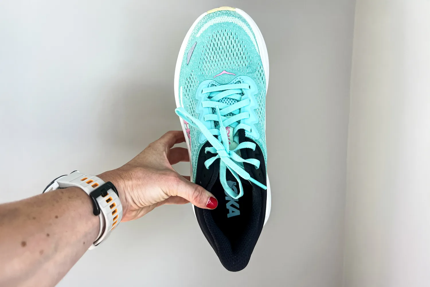 A person holds up the Hoka Women's Bondi 9 Running Shoe