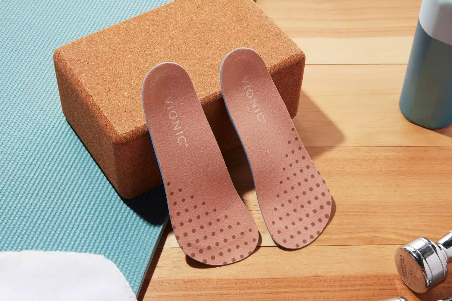 Vionic Slimfit Orthotic Insoles displayed against a yoga block on a wood floor