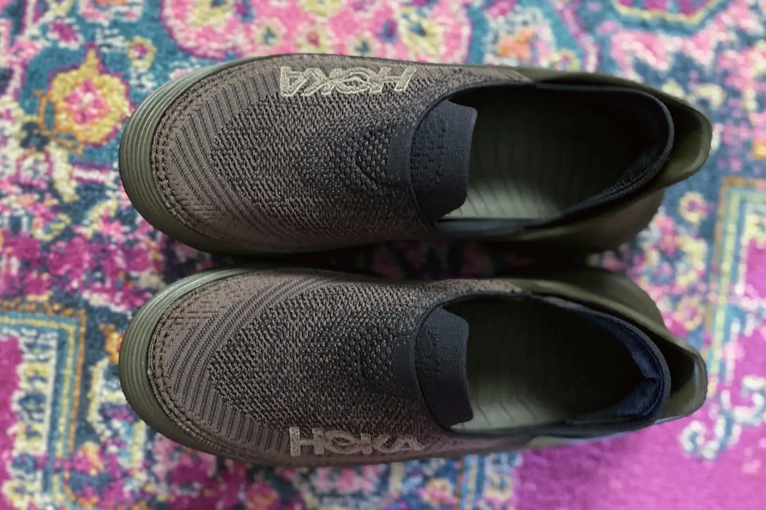 Hoka Restore TC Recovery Shoes on a rug