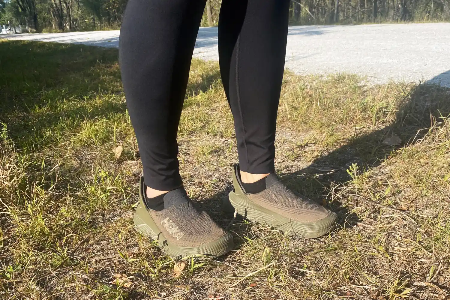 Two legs facing slightly to the side while wearing Hoka Restore TC Recovery Shoes