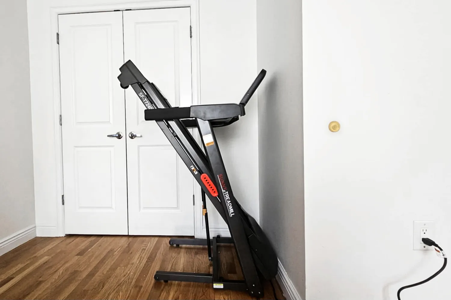 The Sunny Health & Fitness Active 400 Smart Auto Incline Wi-Fi Treadmill folded in a vertical position