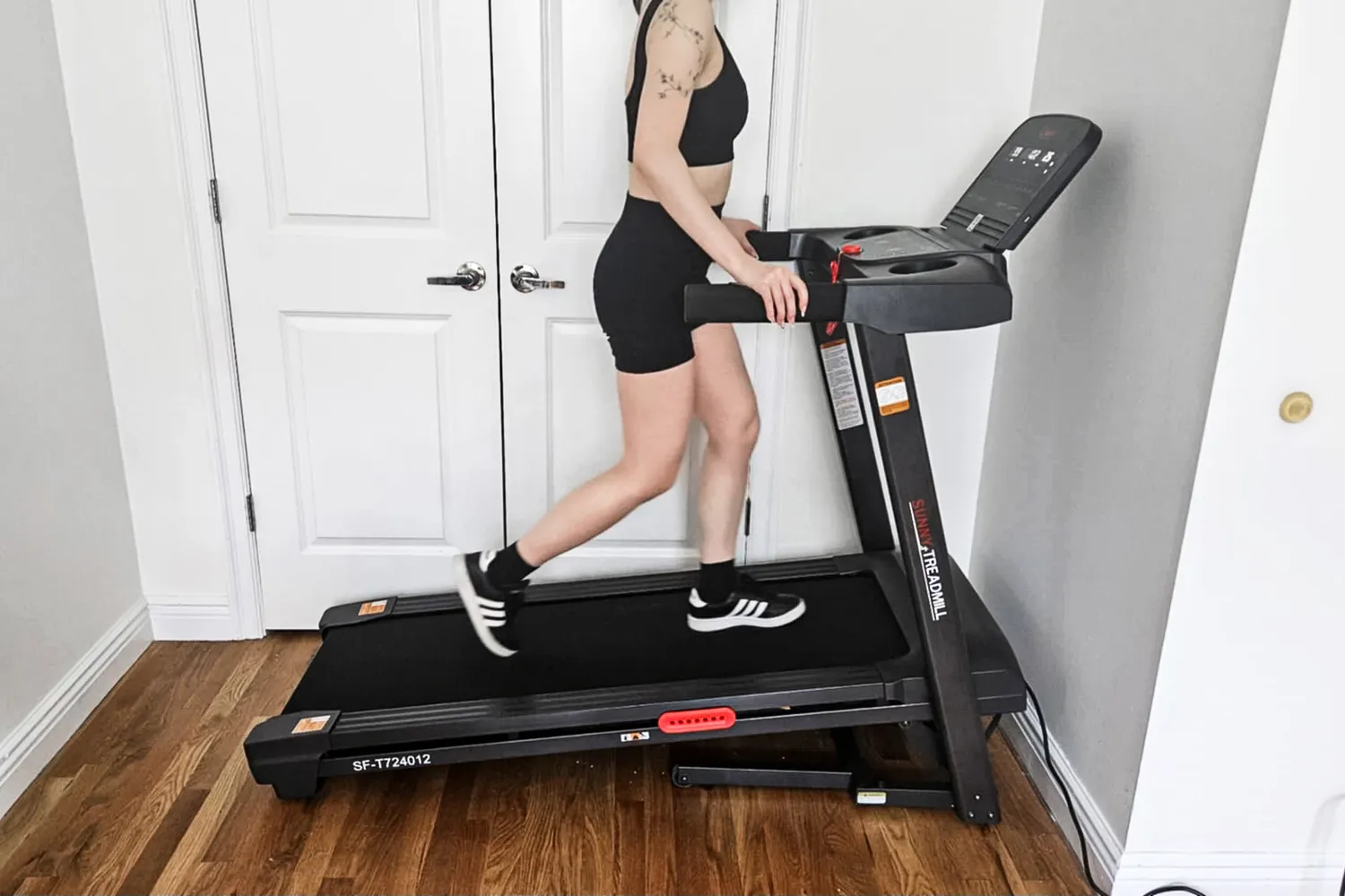 A person walking at an incline on the Sunny Health & Fitness Active 400 Smart Auto Incline Wi-Fi Treadmill