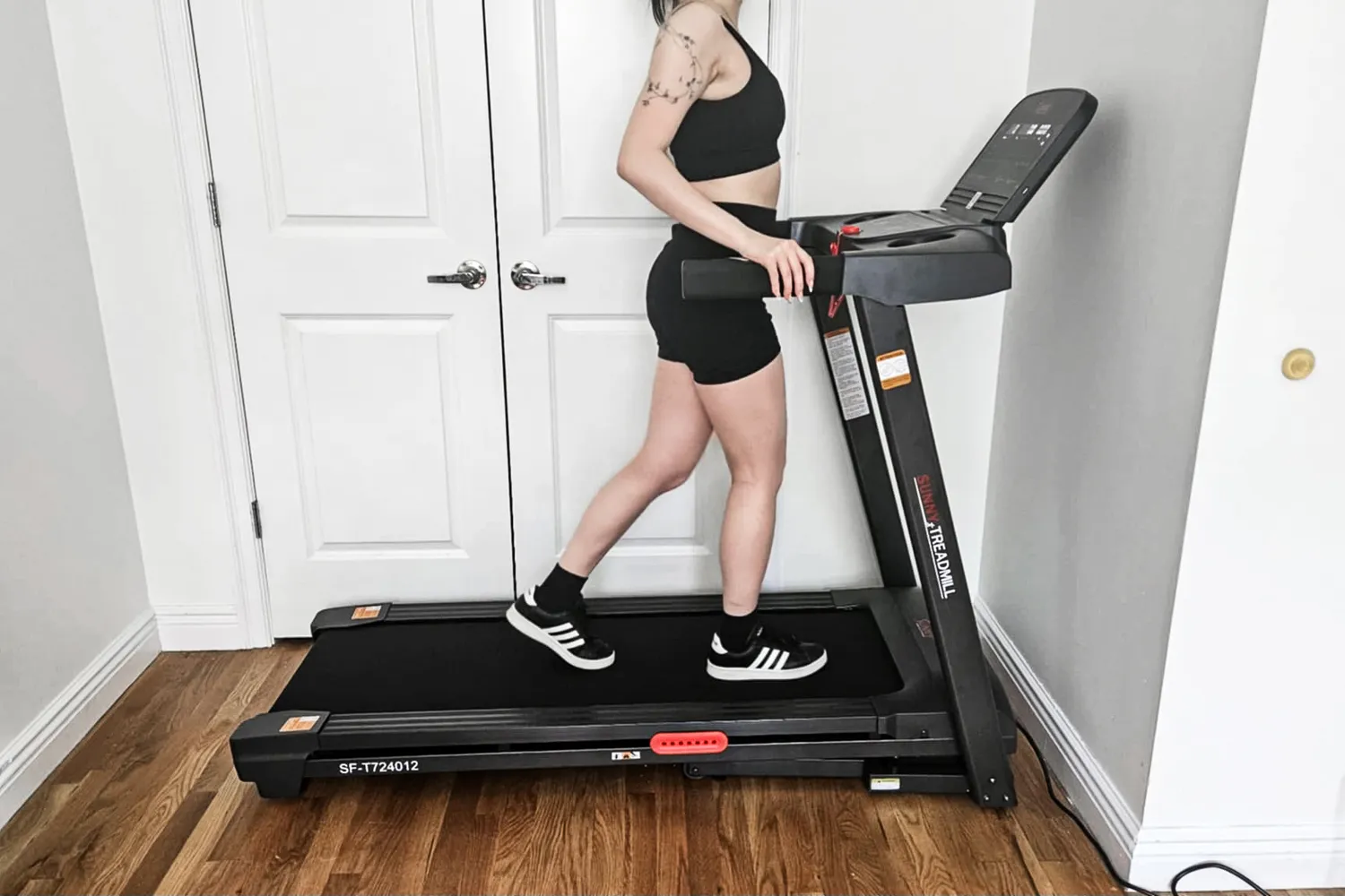 A side view of a person walking on the Sunny Health & Fitness Active 400 Smart Auto Incline Wi-Fi Treadmill