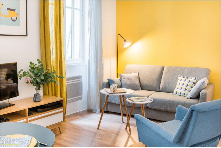 small cozy paris living room with yellow accent wall