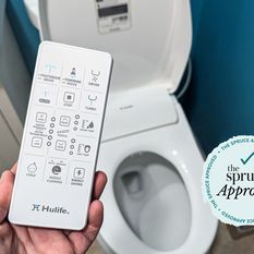 A person holds up the remote control for the Hulife Electric Bidet Seat