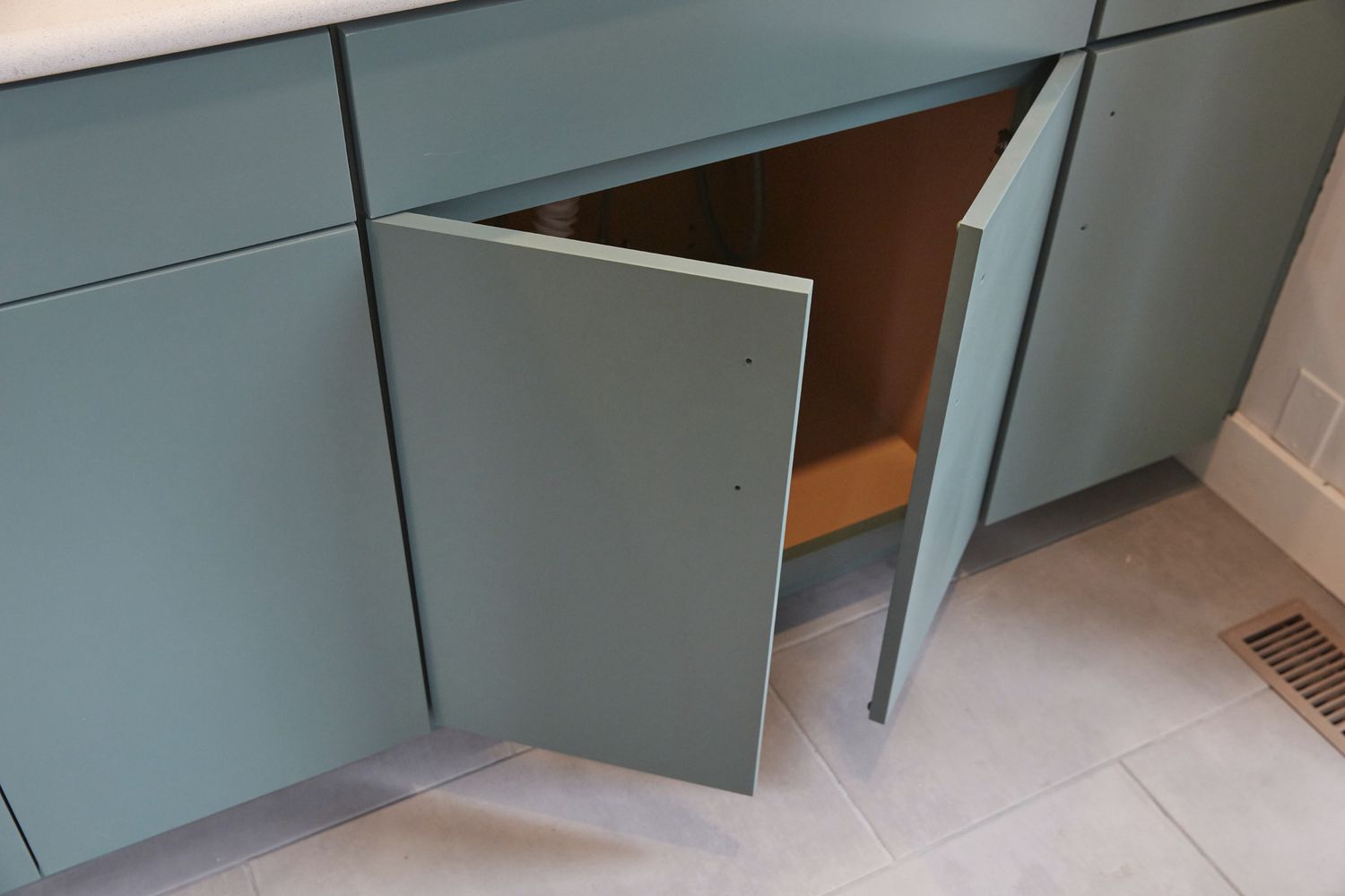 Newly installed mint green kitchen cabinets with doors open