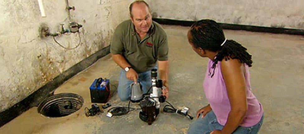 Richard Trethewey lays out his equipment and prepares to show a homeowner how to install a sump pump.