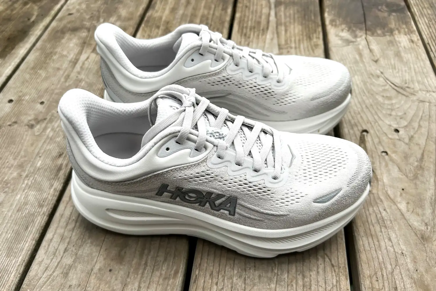 The side-view of the Hoka Bondi 9 shoes posed on wood