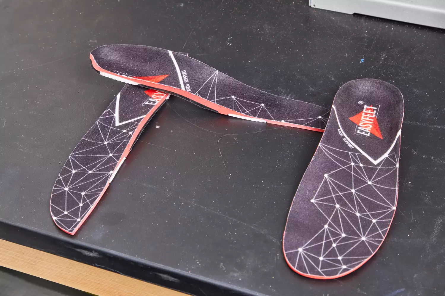 EasyFeet Plantar Fasciitis Arch Support Insoles displayed on a black table with one cut in half