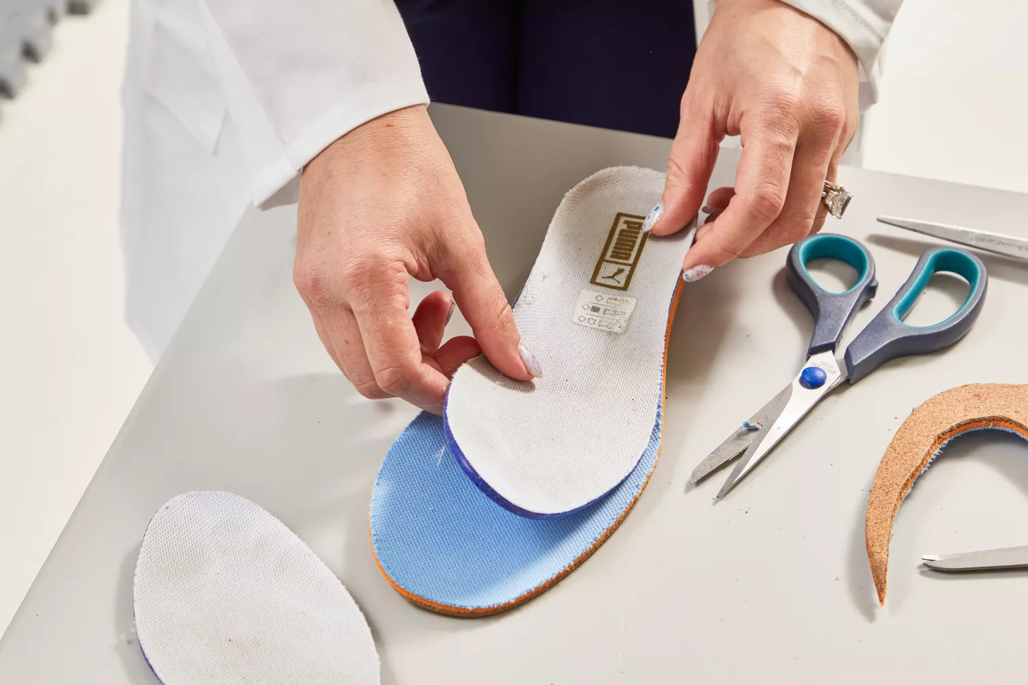 Hands laying an insole on top of a Fulton Athletic Insole