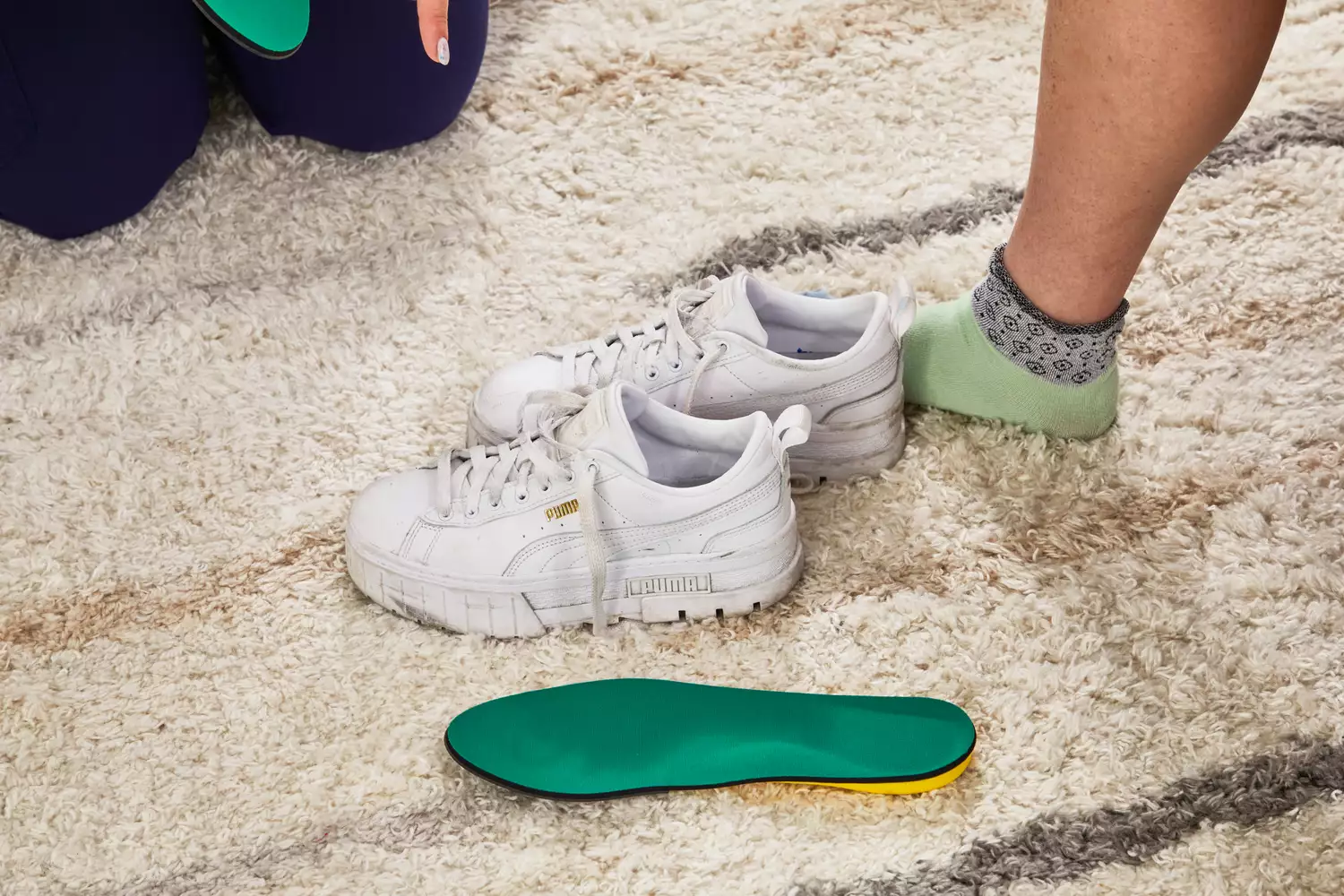 Spenco PolySorb Cross Trainer Insole displayed on fluffy carpet next to white sneakers