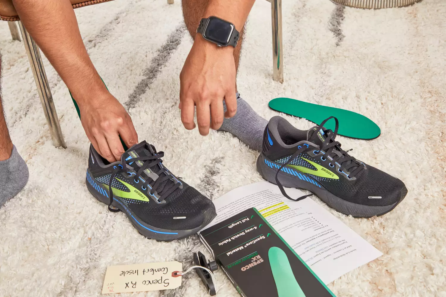 Hand putting a Spenco RX Comfort Insole into a sneaker