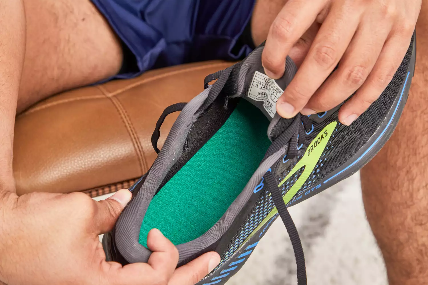 Hands holding a sneaker and displaying the Spenco RX Comfort Insole inside
