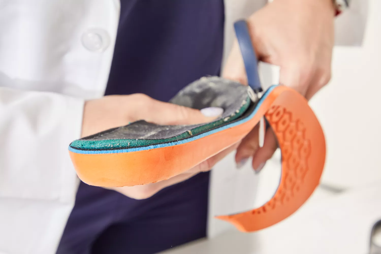 Hands trimming a Timberland Pro Anti-Fatigue Technology Insole with scissors