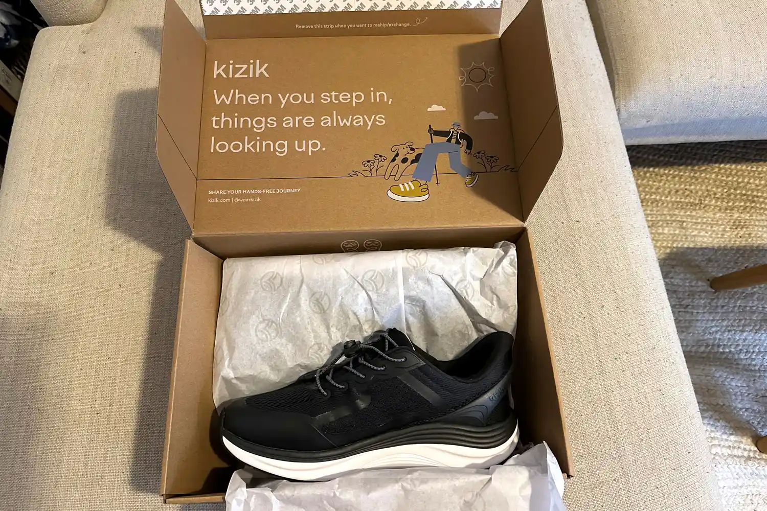 The Kizik Men's London sneakers in the box on fabric