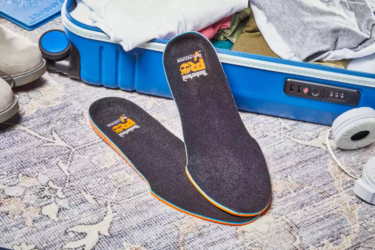 Timberland Pro Anti-Fatigue Technology Insoles displayed on carpet next to a suitcase