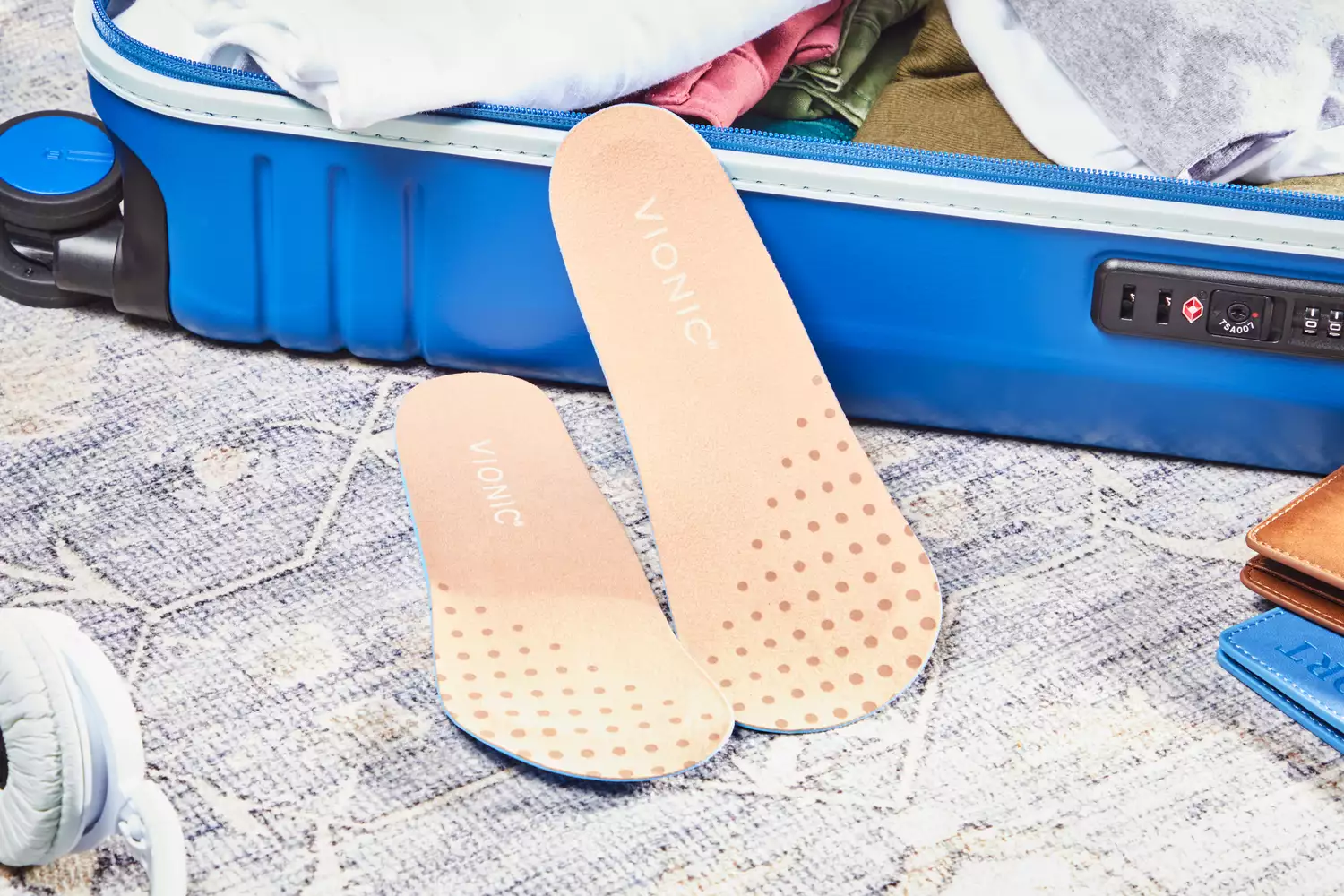 Vionic Slimfit Orthotic Insoles displayed on carpet next to a suitcase