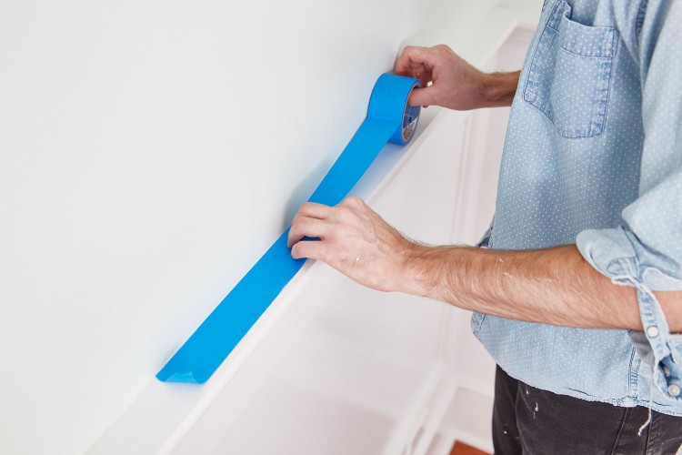 Applying painters tape to wall