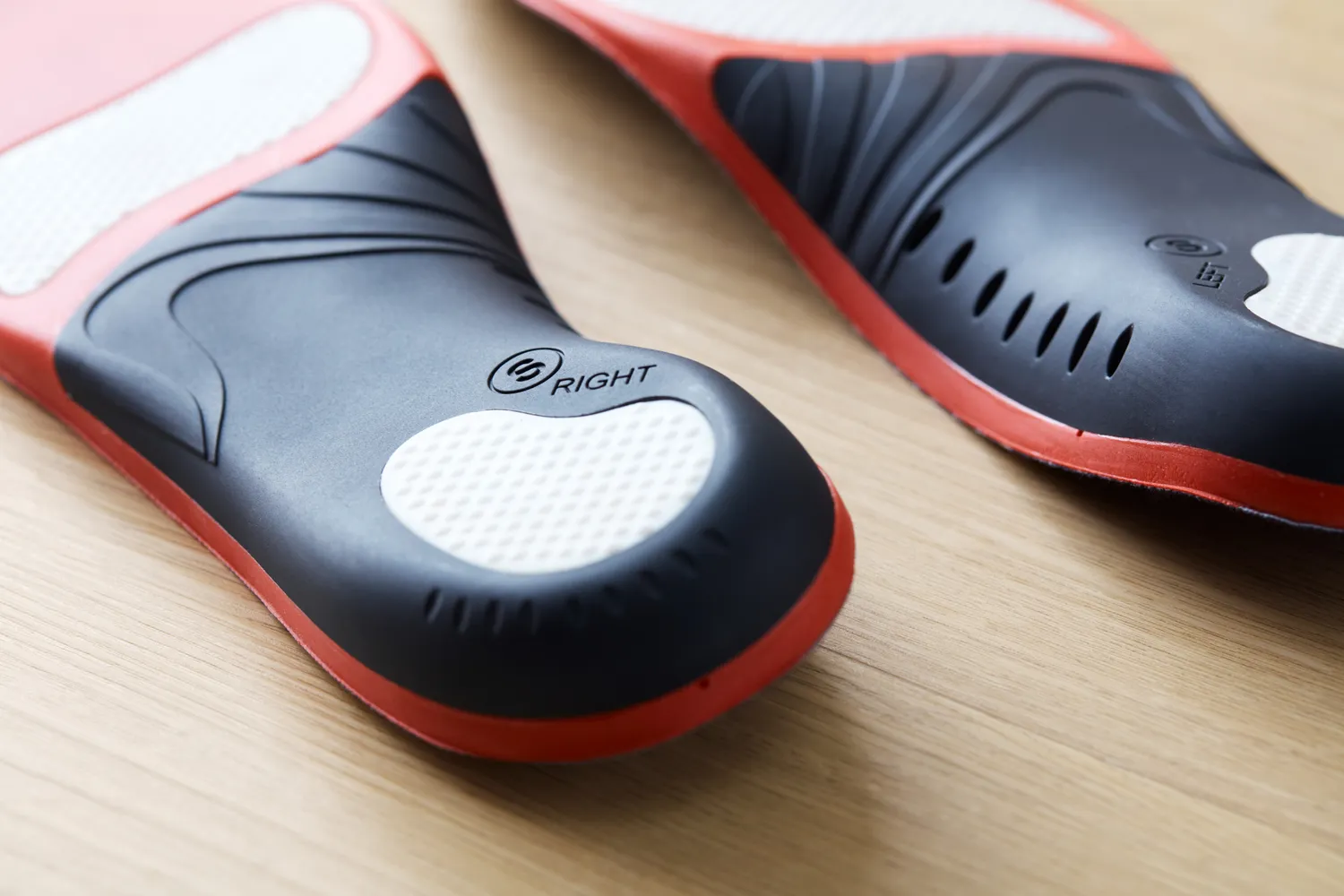 Bottom of EasyFeet Plantar Fasciitis Arch Support Insoles displayed on a wood surface