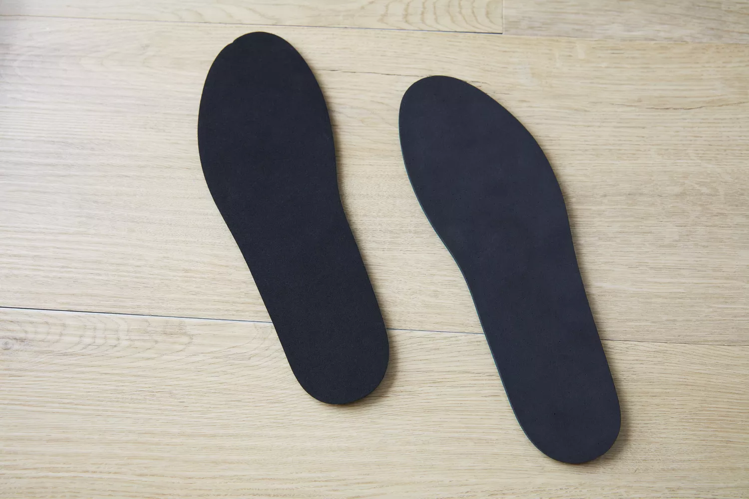 The bottom of the Spenco RX Comfort Insole on a wooden floor