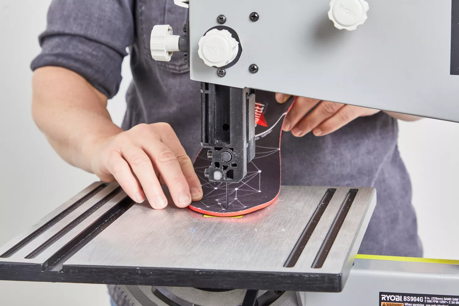 Person cutting an EasyFeet Plantar Fasciitis Arch Support Insole in half with a band saw
