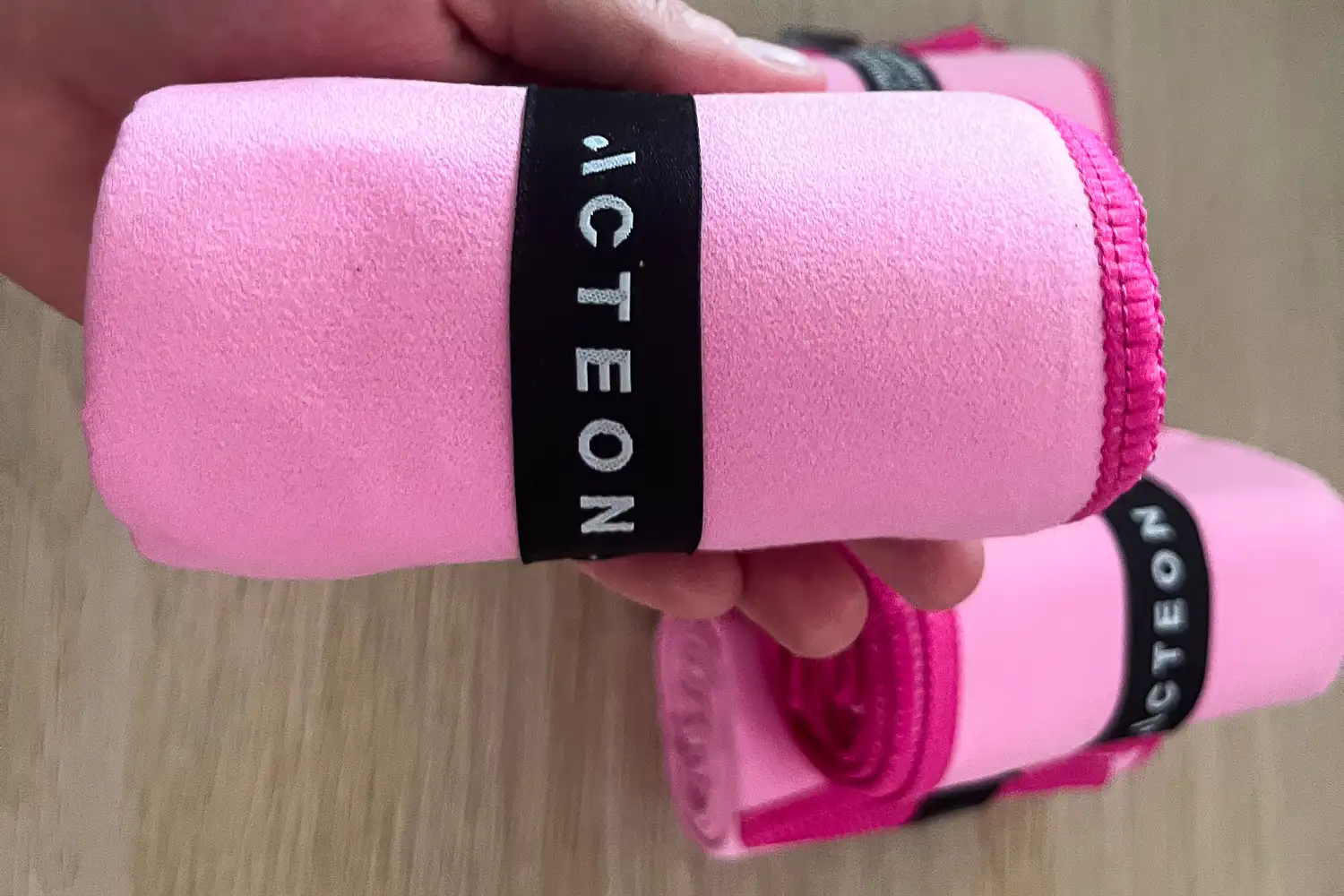 The Acteon Microfiber Quick Dry Gym Towel rolled up and secured with a branded strap