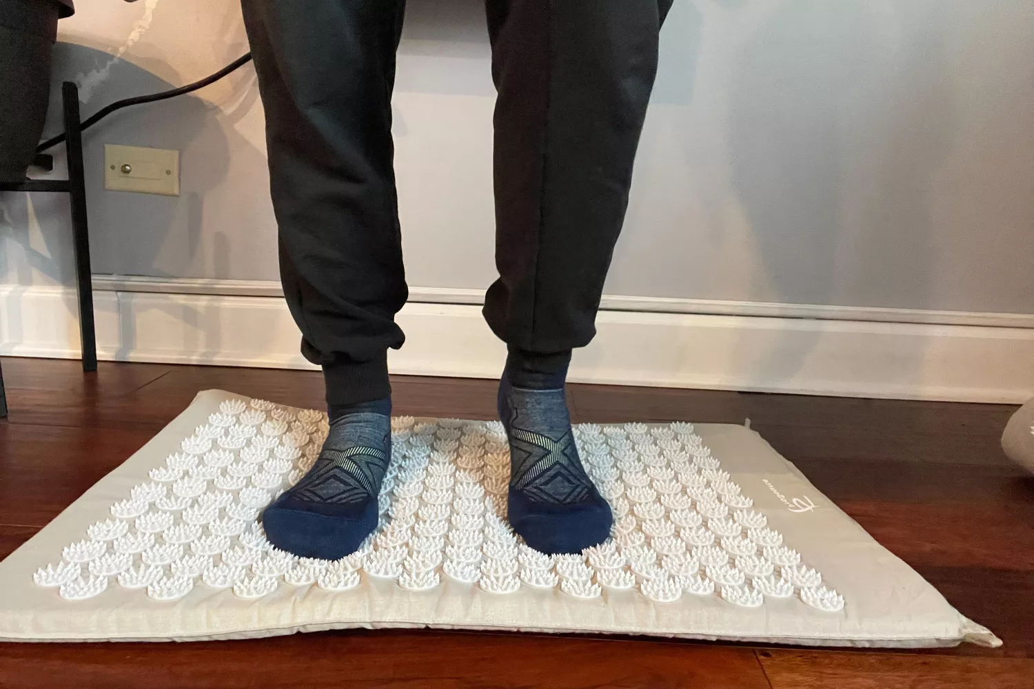 Person wearing socks standing on the ProsourceFit Acupressure Mat and Pillow Set