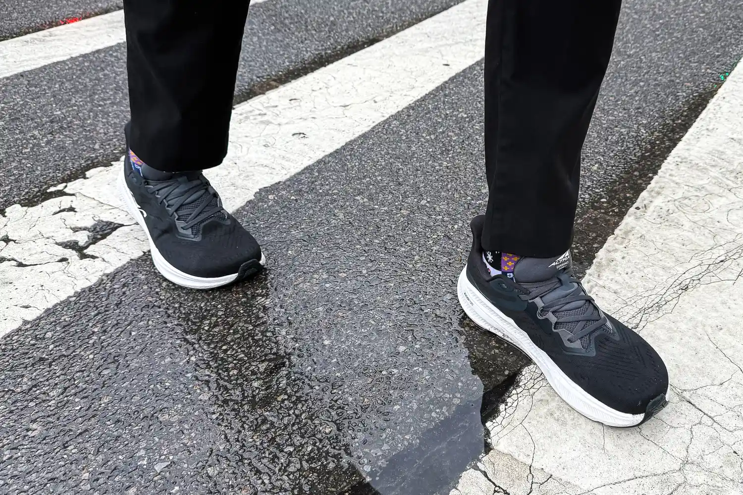 A person walks outside in the rain while wearing the Altra Men's Experience Flow 2 Sneakers
