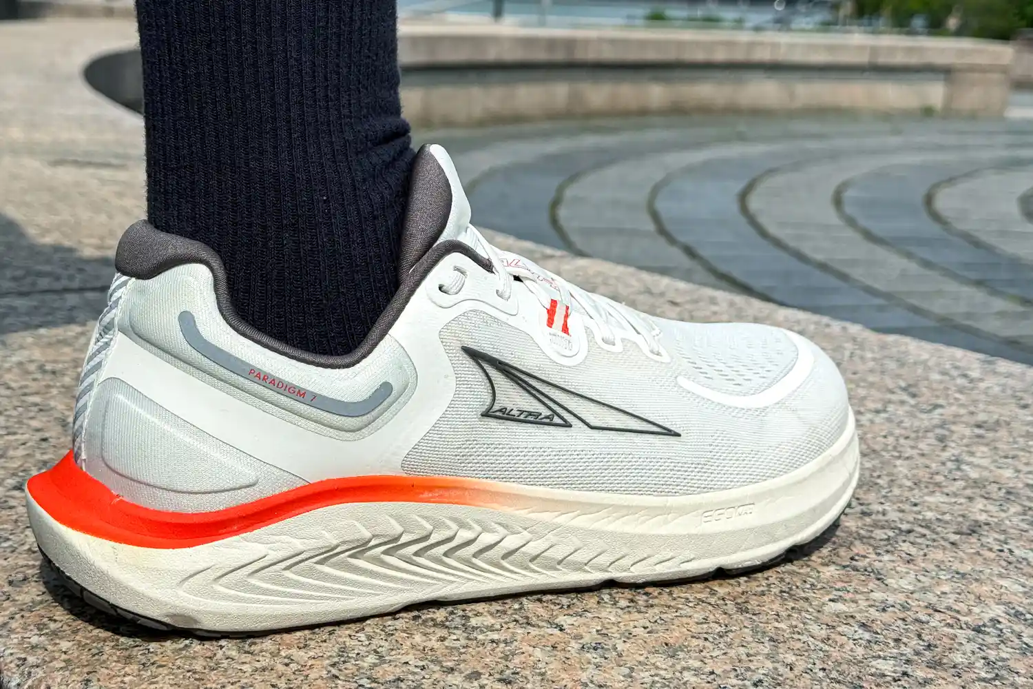 A person wears the Altra Men's Paradigm 7 Sneakers while walking outside