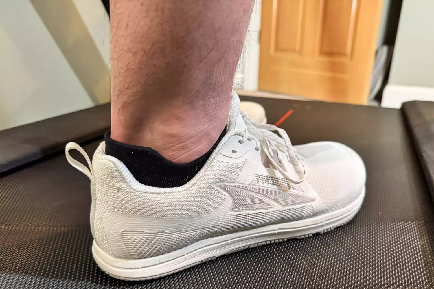 A close-up of the Altra Men's Solstice XT 3 sneaker worn on a treadmill