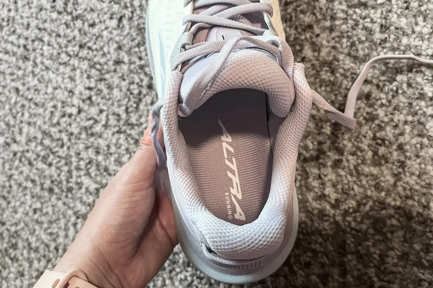 A person holds up the Altra Women's Paradigm 8 Running Shoe