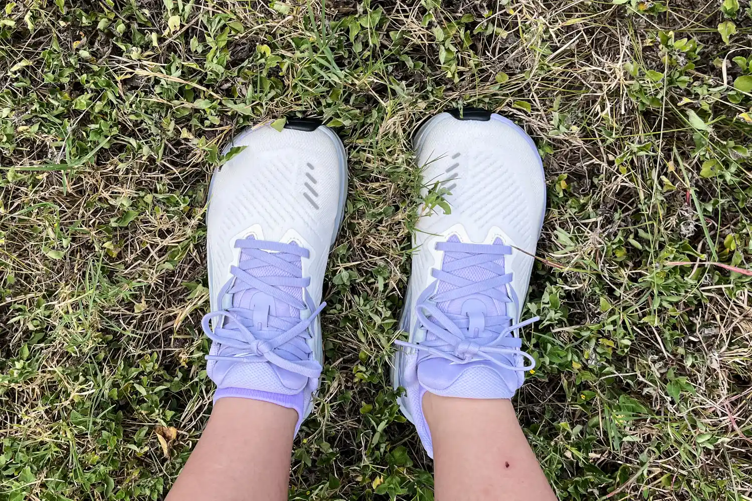 A person wears the Altra Women's Paradigm 8 Running Shoes in grass