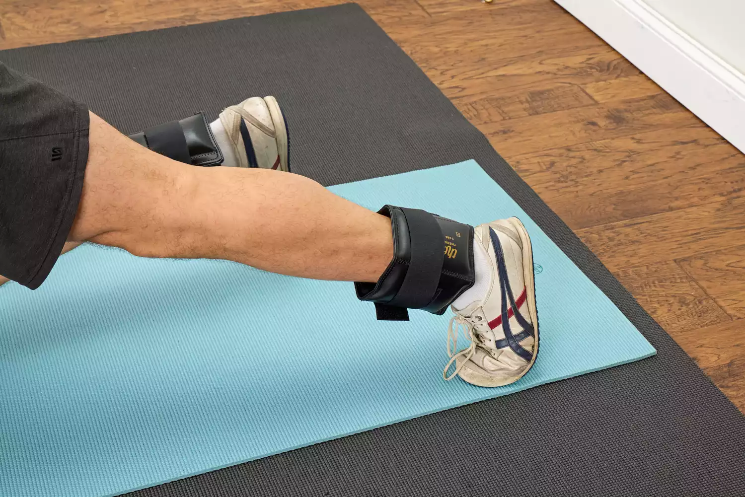 A person wears the The Cuff Original Adjustable Ankle and Wrist Weights on their legs while exercising