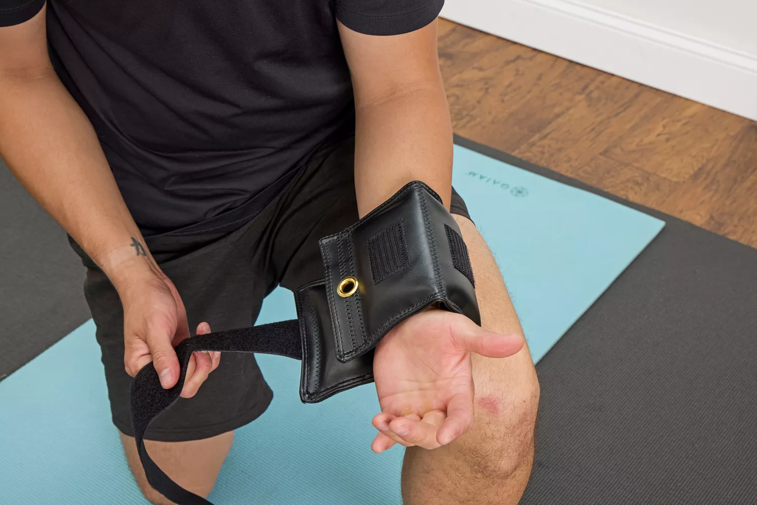 A person tightens the straps on the The Cuff Original Adjustable Ankle and Wrist Weights