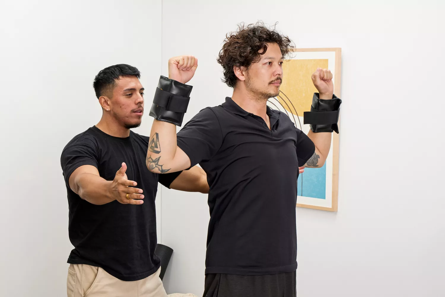 A person lifts their arms while wearing the The Cuff Original Adjustable Ankle and Wrist Weights
