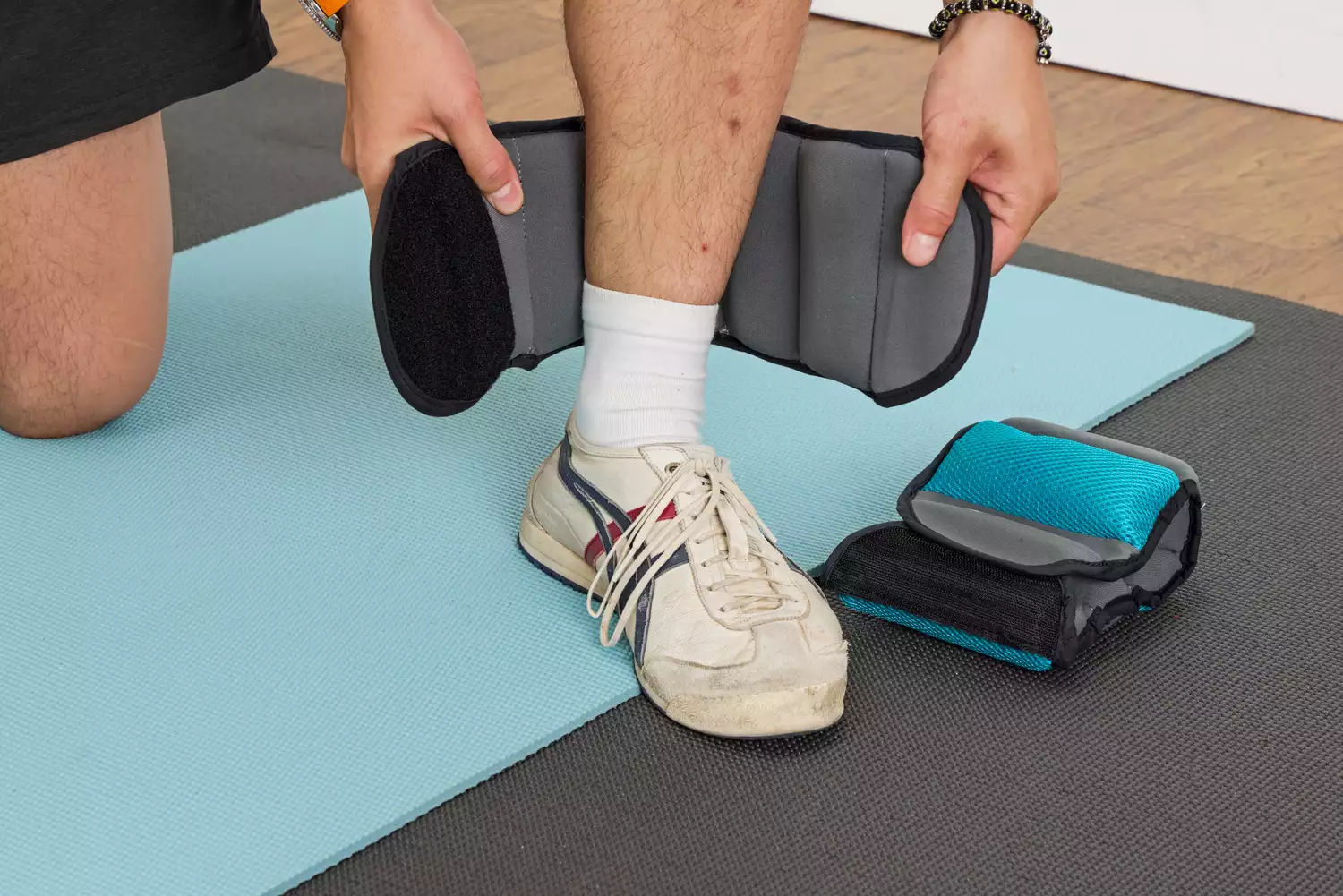 A person places the Gaiam Fitness Ankle Weight onto their ankle