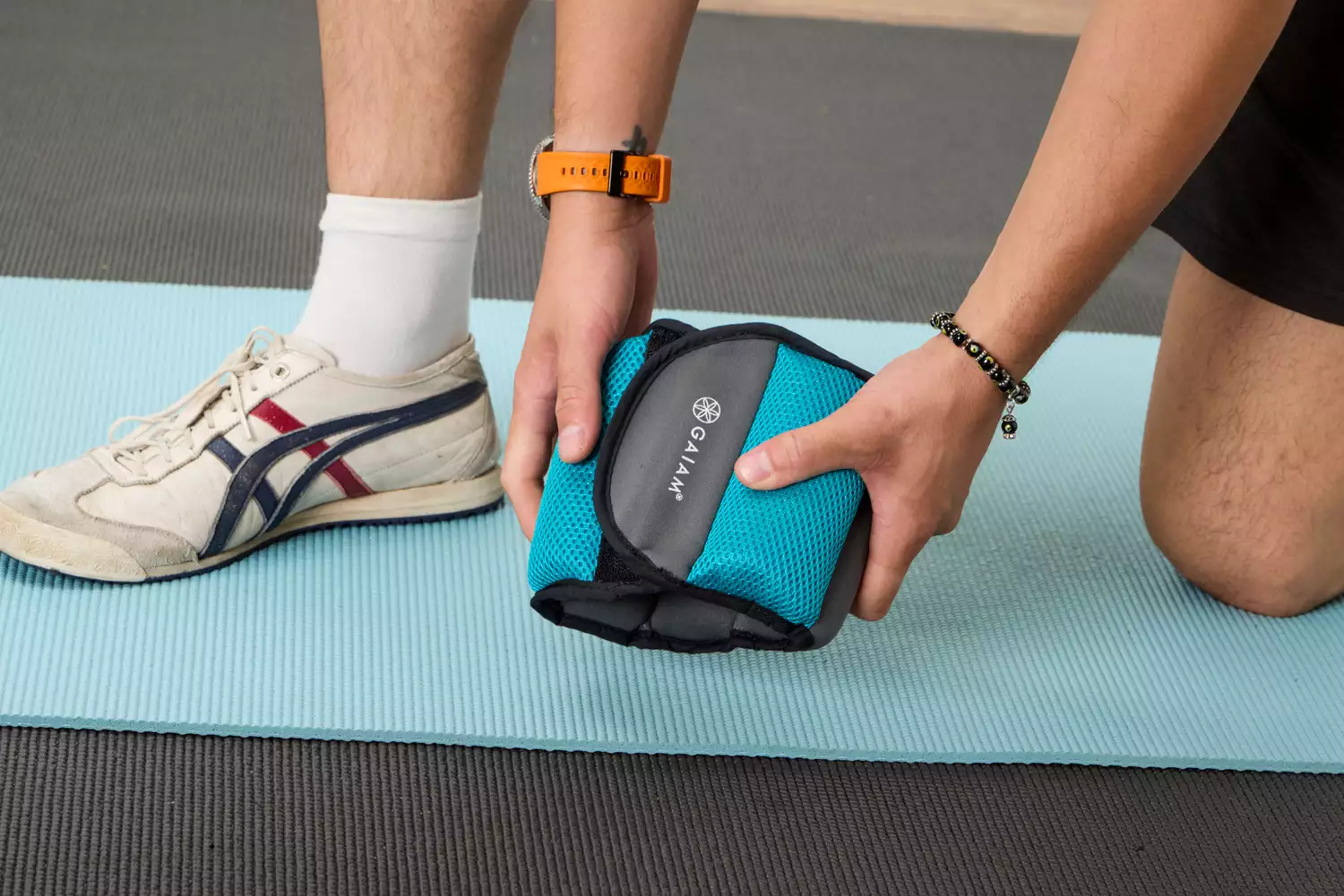 A person picks up the Gaiam Fitness Ankle Weight