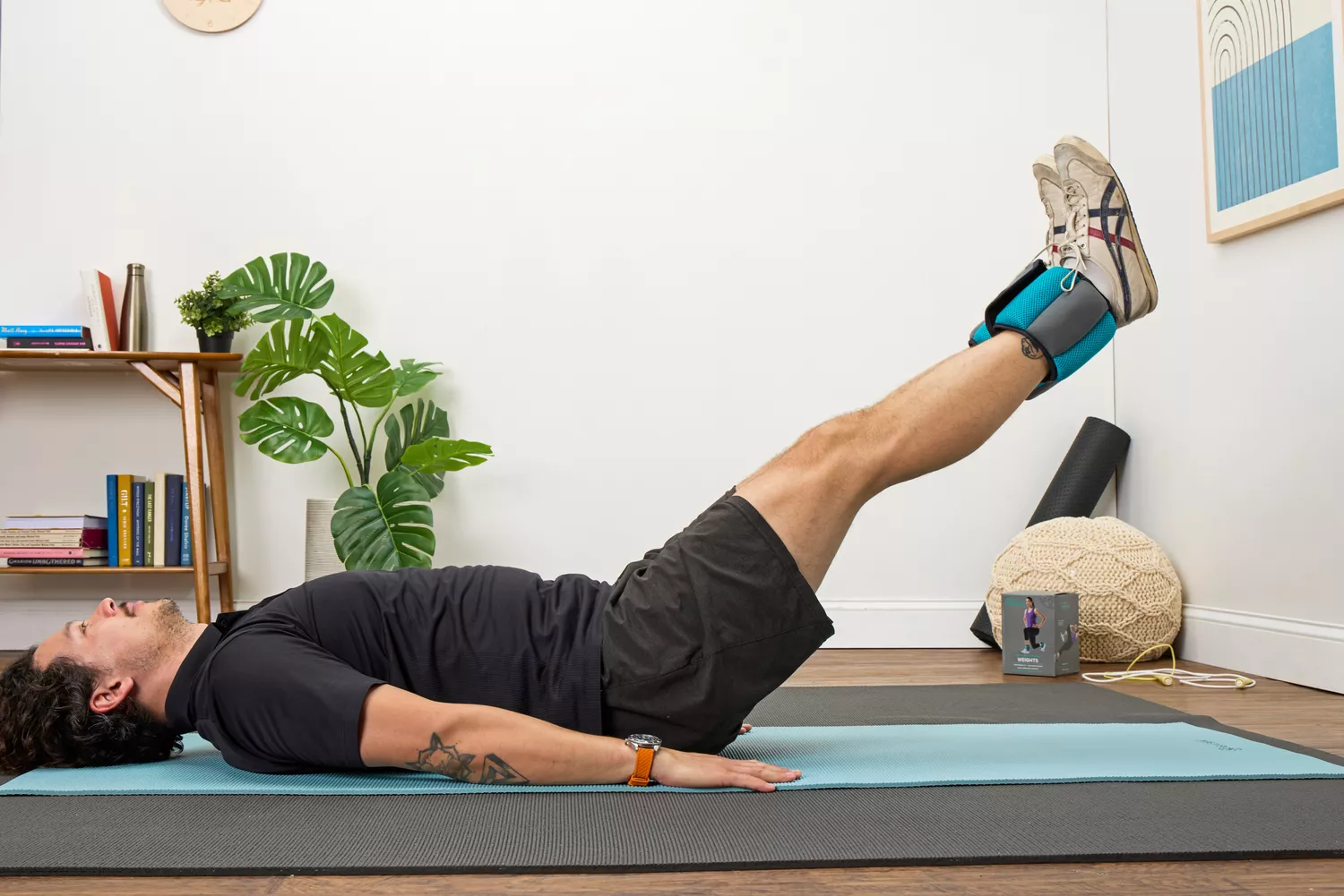 A person does leg lifts while wearing the Gaiam Fitness Ankle Weights