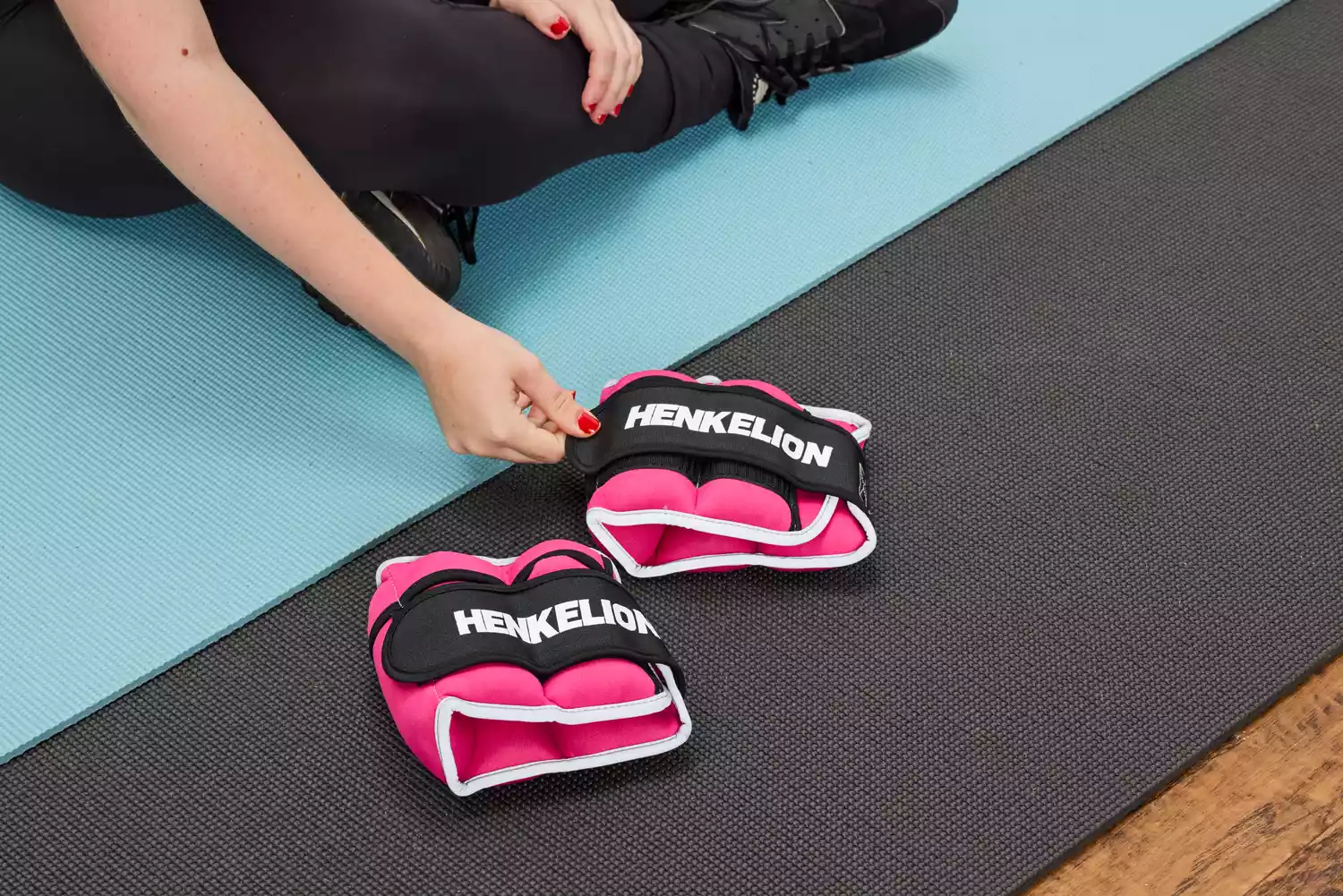 A person prepares to put on the Henkelion Adjustable Ankle Weights