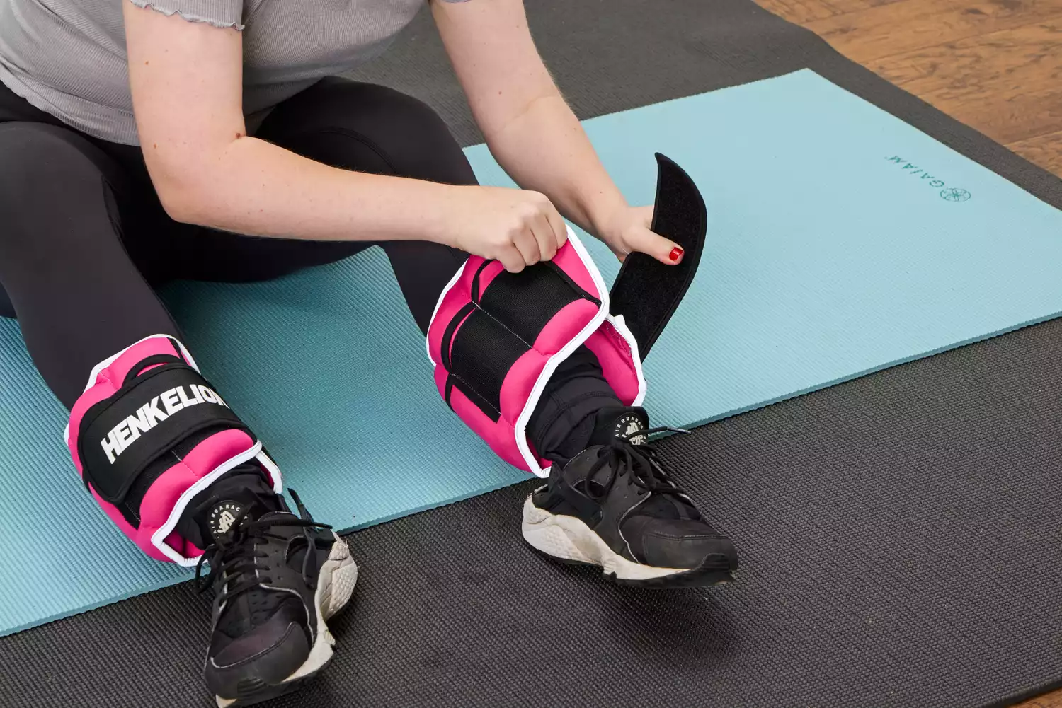 A person places the Henkelion Adjustable Ankle Weights onto their legs