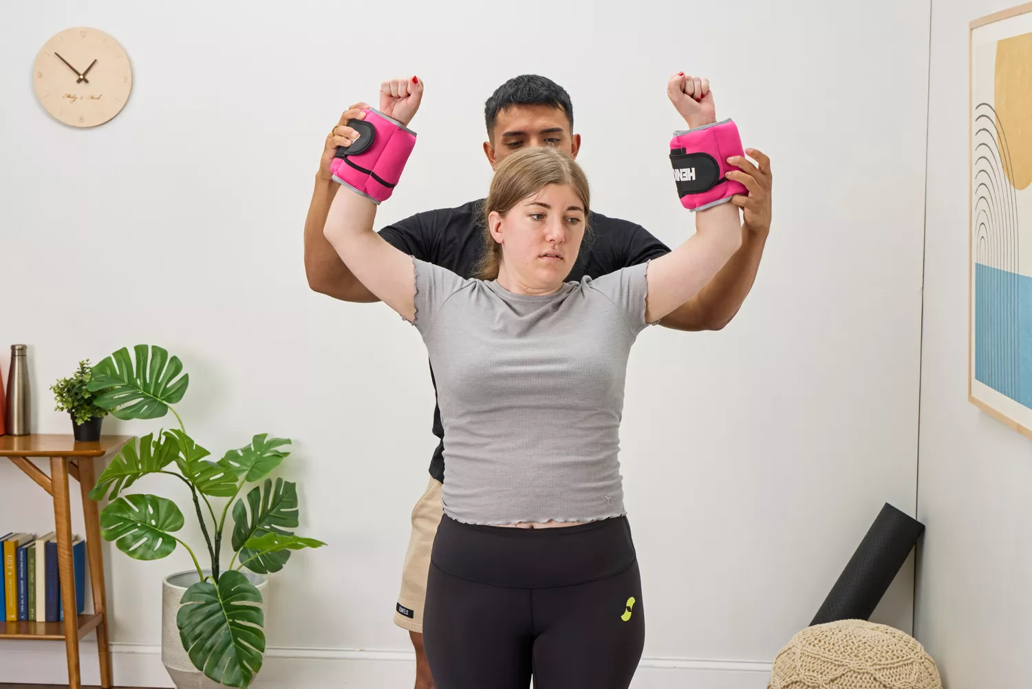 A person lifts their arms while wearing the Henkelion Adjustable Ankle Weights