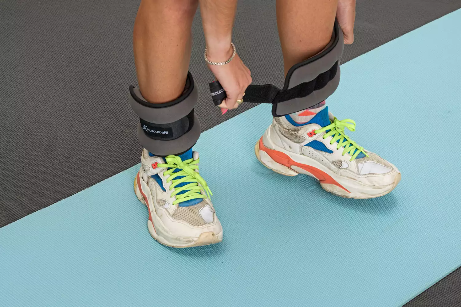 A person wears the ProsourceFit Ankle/Wrist and Arm/Leg Weights on their legs