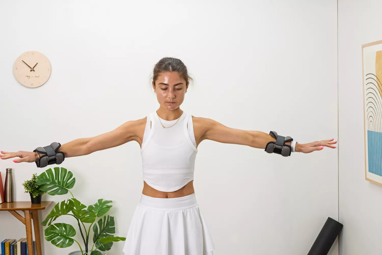 A person raises their arms while wearing the ProsourceFit Ankle/Wrist and Arm/Leg Weights