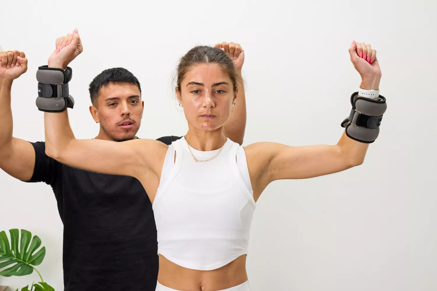A person raises their arms while wearing the ProsourceFit Ankle/Wrist and Arm/Leg Weights