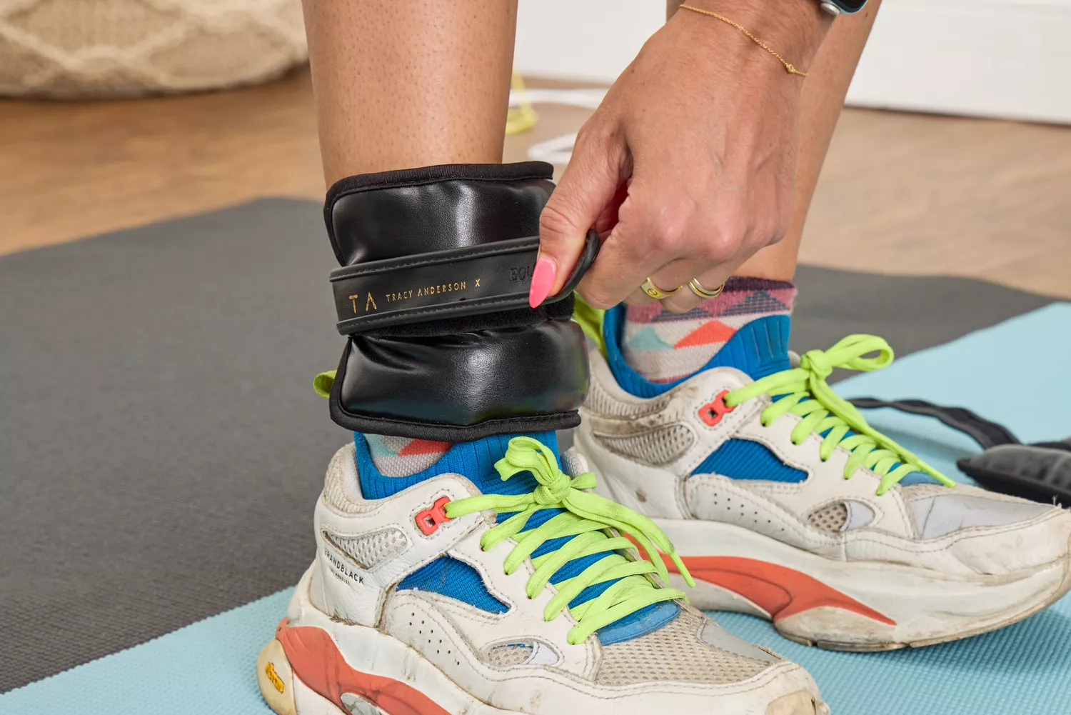 A person tightens the strap on the Tracy Anderson UWRAPS Vegan Leather Ankle/Wrist Weight